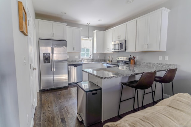41 Eden Ave Unit 3, Southington, CT 06489 - kitchen with appliances with stainless steel finishes, a peninsula, light stone countertops, white cabinets, and dark wood-style floors