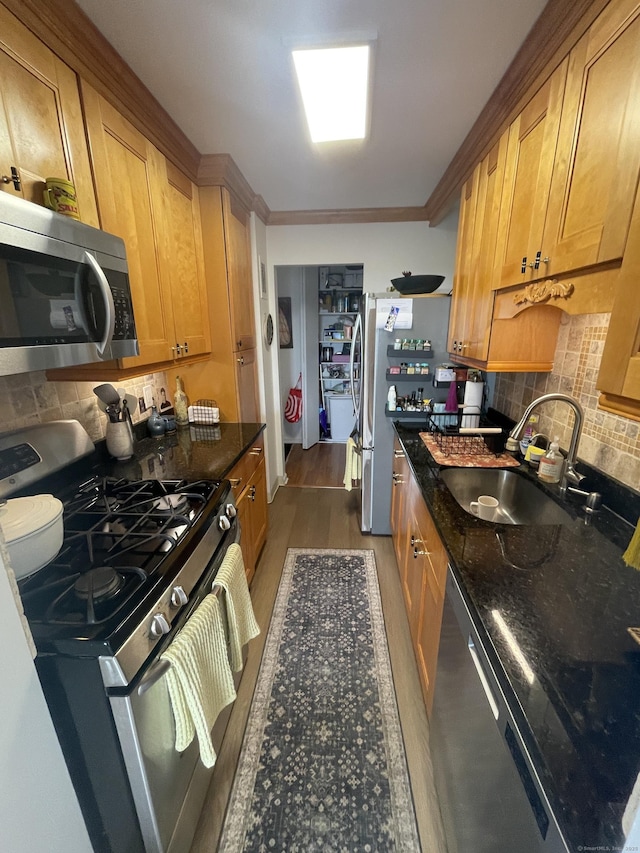 2625 Park Ave Unit 11P, Bridgeport, CT 06604 - kitchen featuring appliances with stainless steel finishes, decorative backsplash, ornamental molding, dark stone countertops, and dark wood finished floors