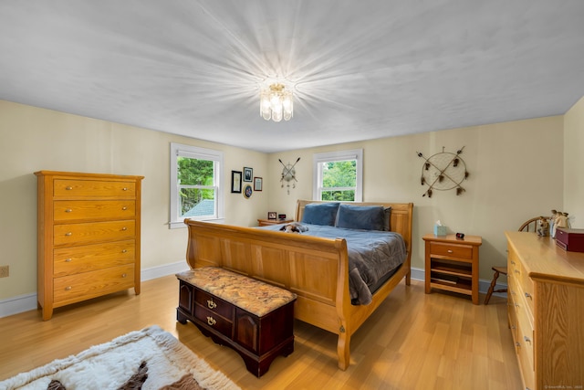 128 Holcomb Hill Rd, New Hartford, CT 06057 - bedroom with light wood-style floors, multiple windows, and a chandelier