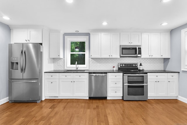 24 Main St, East Hampton, CT 06424 - kitchen featuring stainless steel appliances, dark countertops, light wood-type flooring, and recessed lighting