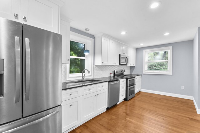 24 Main St, East Hampton, CT 06424 - kitchen featuring appliances with stainless steel finishes, light wood finished floors, white cabinets, backsplash, and recessed lighting