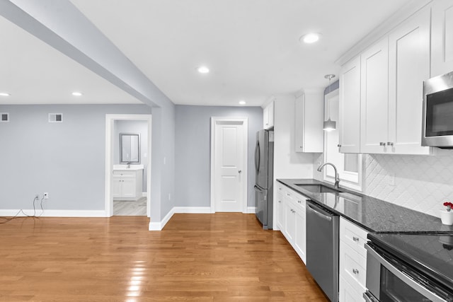 24 Main St, East Hampton, CT 06424 - kitchen featuring appliances with stainless steel finishes, white cabinets, recessed lighting, light wood finished floors, and backsplash