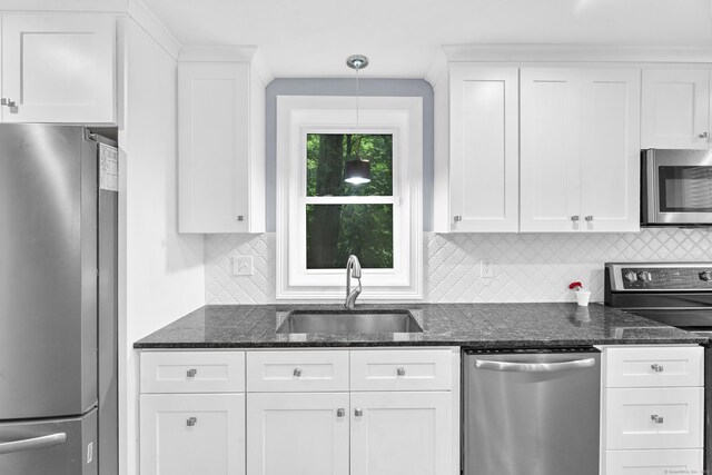 24 Main St, East Hampton, CT 06424 - kitchen featuring stainless steel appliances, backsplash, white cabinetry, and dark stone counters