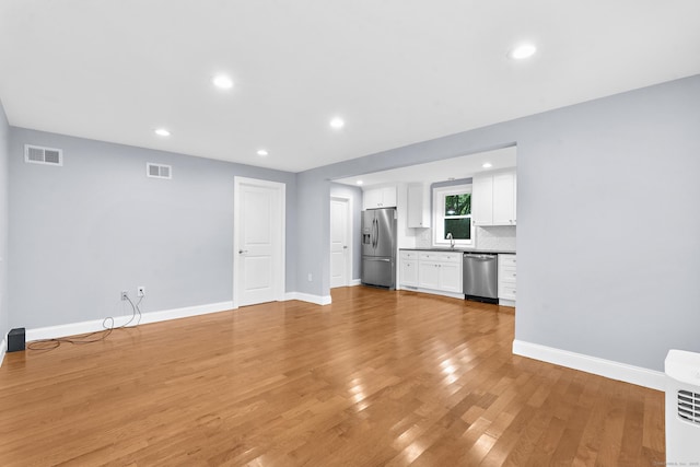 24 Main St, East Hampton, CT 06424 - unfurnished living room with light wood finished floors and recessed lighting