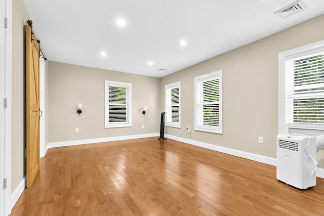 24 Main St, East Hampton, CT 06424 - empty room with light wood finished floors, healthy amount of natural light, recessed lighting, and a barn door