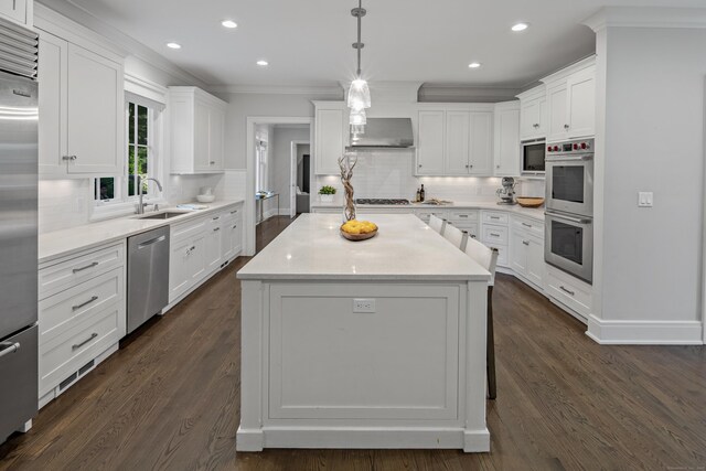 16 Gault Park Dr, Westport, CT 06880 - kitchen featuring stainless steel appliances, wall chimney exhaust hood, tasteful backsplash, white cabinetry, and crown molding
