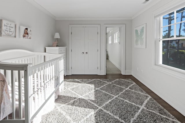 16 Gault Park Dr, Westport, CT 06880 - bedroom with multiple windows, dark wood-style floors, crown molding, a closet, and a nursery area