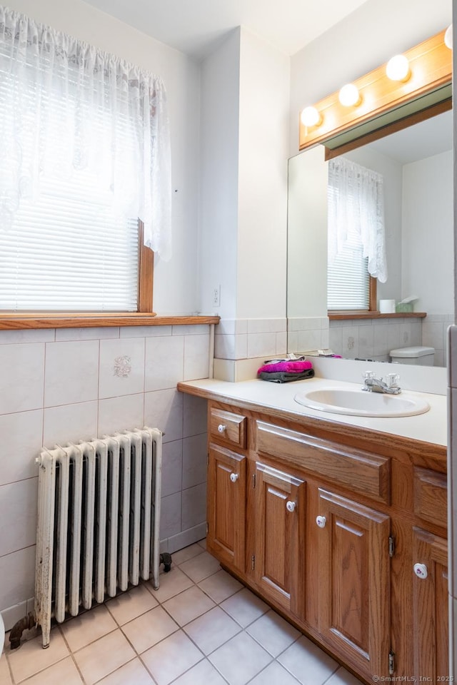 270 Decicco Rd, Waterbury, CT 06705 - bathroom featuring radiator heating unit, vanity, tile walls, and tile patterned floors