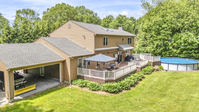 15 Quigley Rd, Wallingford, CT 06492 - rear view of house featuring a deck, a lawn, an outdoor pool, driveway, and roof with shingles
