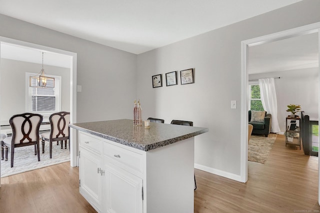 9 Renee Ln, Enfield, CT 06082 - kitchen with light wood-style floors, a center island, white cabinets, and decorative light fixtures