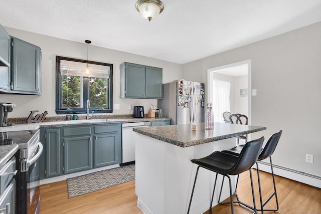 9 Renee Ln, Enfield, CT 06082 - kitchen with appliances with stainless steel finishes, a breakfast bar, light wood-style floors, hanging light fixtures, and a center island