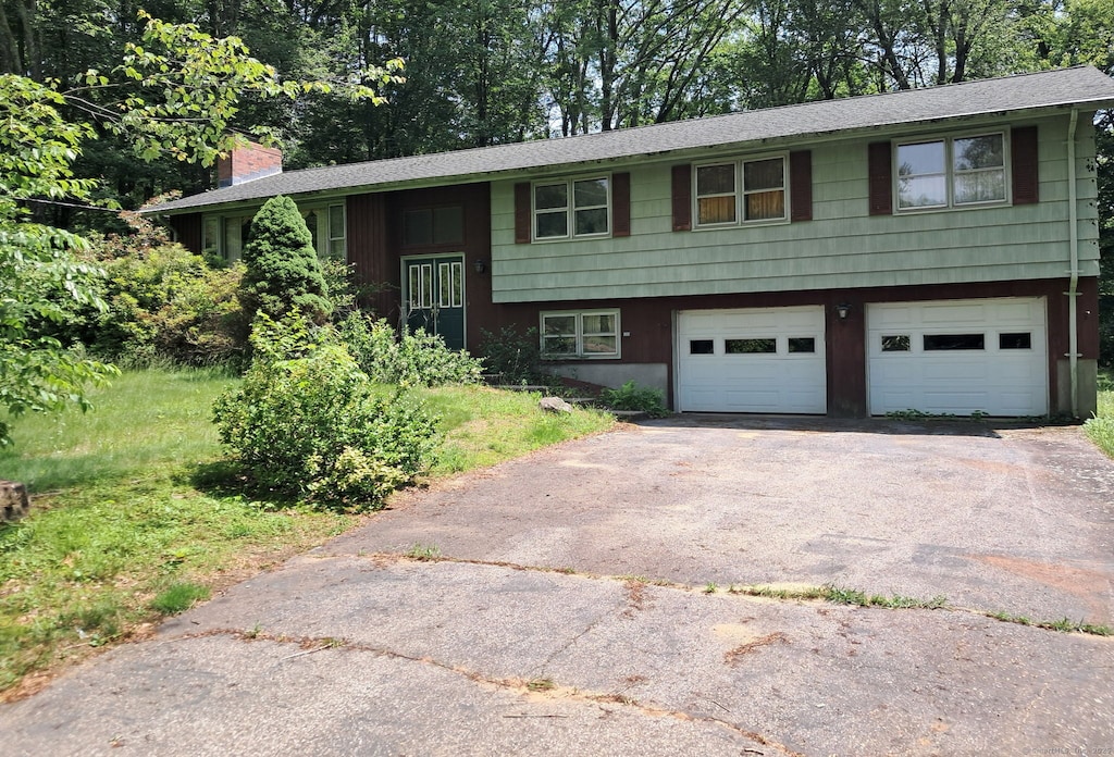 71 Blue Ridge Dr, Manchester, CT 06040 - split foyer home with asphalt driveway, a garage, a chimney, and roof with shingles
