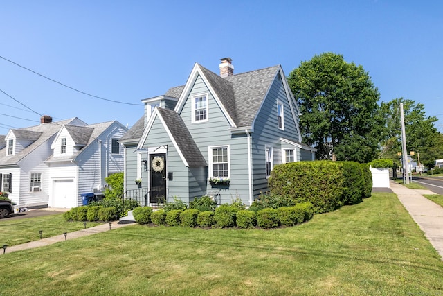 32 Holcomb St, West Haven, CT 06516 - view of front of house featuring a front yard, a garage, and a chimney