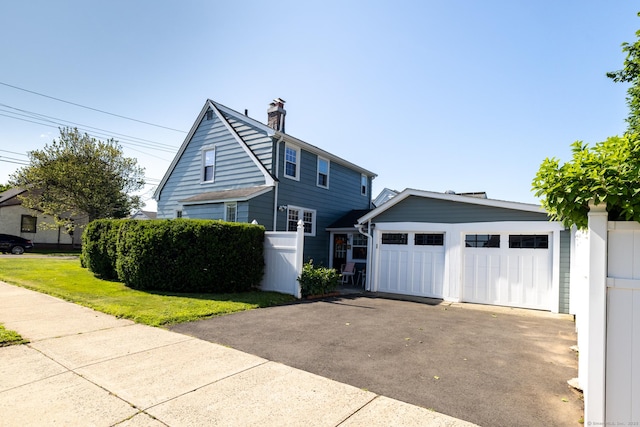 32 Holcomb St, West Haven, CT 06516 - view of front of home featuring a chimney, asphalt driveway, and an attached garage