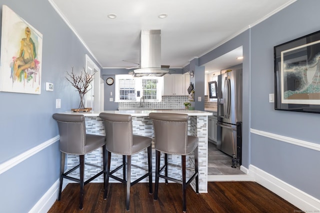32 Holcomb St, West Haven, CT 06516 - kitchen featuring stainless steel refrigerator with ice dispenser, a breakfast bar area, dark wood finished floors, light countertops, and decorative backsplash