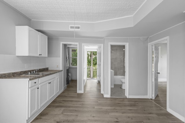 37 William St, Waterbury, CT 06702 - kitchen featuring white cabinetry, dark countertops, wood finished floors, and tasteful backsplash