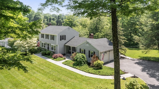 46 Tally Ho Rd, Ridgefield, CT 06877 - view of front of home with a chimney, a garage, driveway, a front lawn, and roof with shingles