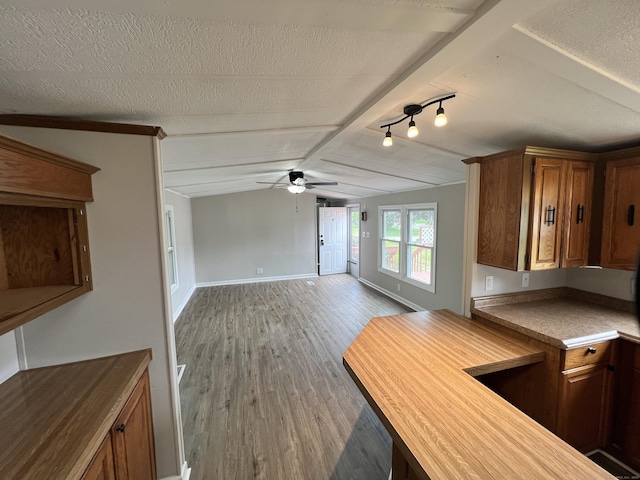 26 Jacqueline Ln, Windham, CT 06256 - kitchen with wood finished floors, ceiling fan, vaulted ceiling, brown cabinetry, and open floor plan