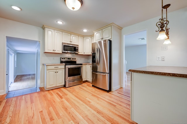 140 Braeside Dr, Hamden, CT 06514 - kitchen with stainless steel appliances, cream cabinets, light wood-type flooring, decorative light fixtures, and recessed lighting