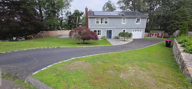 17 Kingsbury Rd, Norwalk, CT 06851 - view of front of house featuring asphalt driveway, an attached garage, roof mounted solar panels, a chimney, and a storage shed