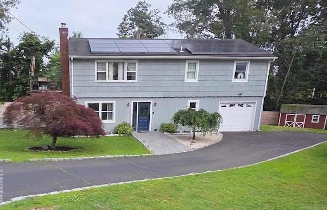17 Kingsbury Rd, Norwalk, CT 06851 - view of front facade with a chimney, a garage, a front yard, solar panels, and driveway