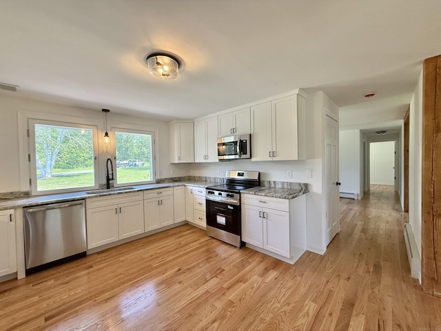 249 Wall St, Hebron, CT 06248 - kitchen with stainless steel appliances, light wood-style flooring, white cabinetry, a baseboard heating unit, and baseboard heating