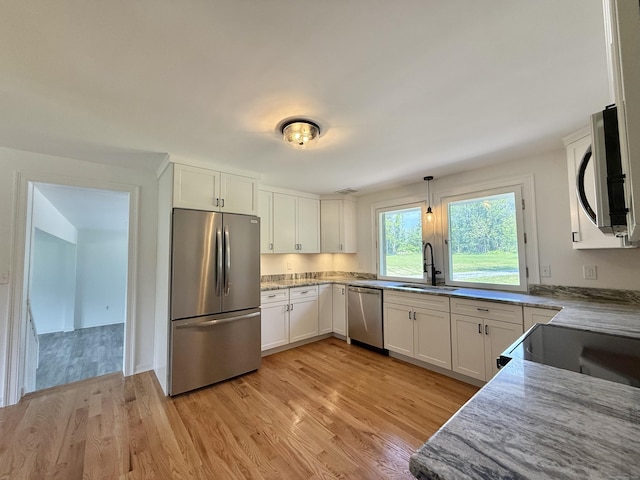 249 Wall St, Hebron, CT 06248 - kitchen with appliances with stainless steel finishes, light wood finished floors, white cabinetry, and pendant lighting
