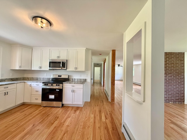 249 Wall St, Hebron, CT 06248 - kitchen featuring stainless steel appliances, baseboard heating, light wood-style flooring, and white cabinetry