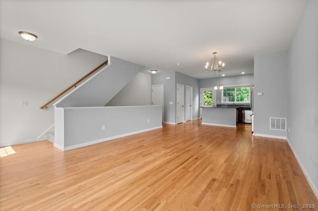 3 Riverview Ct Unit 3, Brookfield, CT 06804 - unfurnished living room featuring a chandelier, light wood-type flooring, and stairs