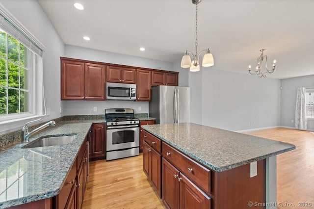 3 Riverview Ct Unit 3, Brookfield, CT 06804 - kitchen featuring appliances with stainless steel finishes, a chandelier, light wood-style floors, a kitchen island, and decorative light fixtures