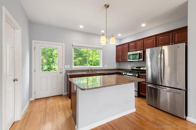 3 Riverview Ct Unit 3, Brookfield, CT 06804 - kitchen featuring stainless steel appliances, light wood-style flooring, hanging light fixtures, dark stone countertops, and a center island