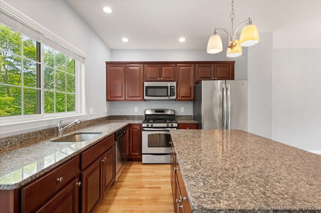 3 Riverview Ct Unit 3, Brookfield, CT 06804 - kitchen featuring stainless steel appliances, a center island, light wood-style floors, decorative light fixtures, and stone countertops