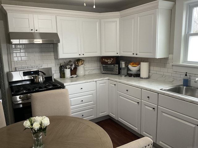 140 Stuart Ave, Norwalk, CT 06850 - kitchen featuring under cabinet range hood, gas stove, white cabinetry, and backsplash