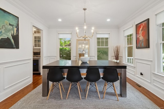 109 W Ave, Darien, CT 06820 - dining room with a chandelier, a decorative wall, dark wood finished floors, crown molding, and wine cooler
