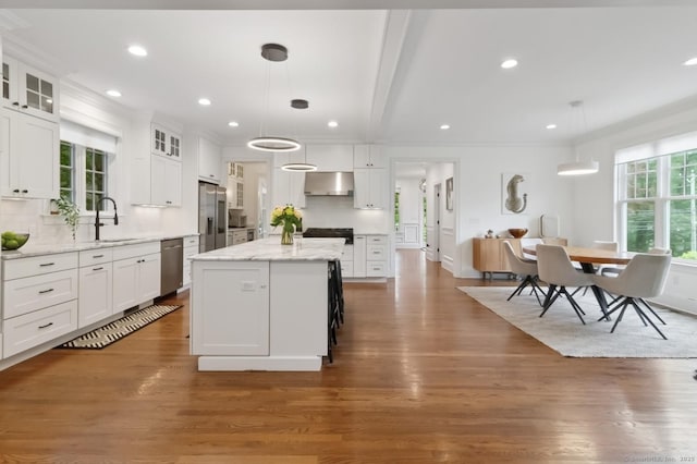 109 W Ave, Darien, CT 06820 - kitchen with appliances with stainless steel finishes, white cabinetry, wood finished floors, a kitchen island, and recessed lighting