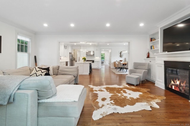 109 W Ave, Darien, CT 06820 - living area with dark wood finished floors, a glass covered fireplace, recessed lighting, and ornamental molding