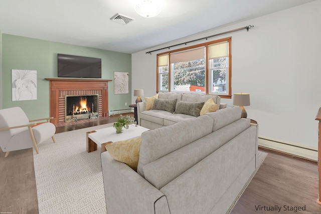 165 Douglas St, Stratford, CT 06614 - living area with baseboard heating, a baseboard heating unit, wood finished floors, and a fireplace