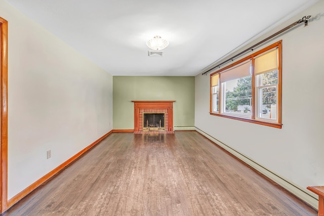 165 Douglas St, Stratford, CT 06614 - unfurnished living room with wood finished floors, a fireplace, and a baseboard heating unit