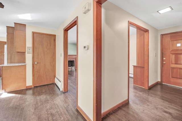 165 Douglas St, Stratford, CT 06614 - entrance foyer featuring a baseboard heating unit, dark wood-style flooring, a fireplace, and a baseboard radiator