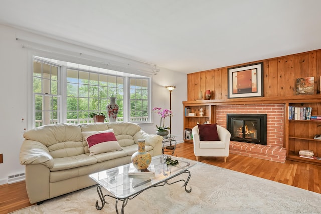 11 Scodon Dr, Ridgefield, CT 06877 - living room with light wood-style flooring, plenty of natural light, a brick fireplace, and wooden walls