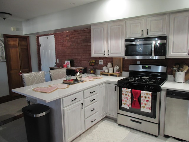 75 Wheeler Ave Unit 205, Bridgeport, CT 06606 - kitchen with stainless steel appliances, light countertops, a peninsula, and decorative backsplash