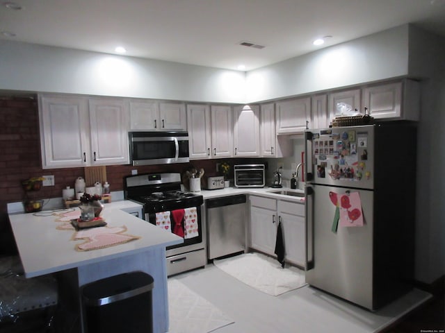 75 Wheeler Ave Unit 205, Bridgeport, CT 06606 - kitchen with appliances with stainless steel finishes, a peninsula, light countertops, a breakfast bar, and recessed lighting