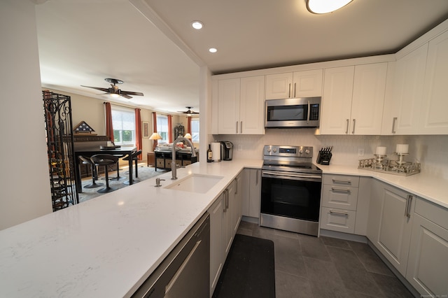 267 Melba St Apt B13, Milford, CT 06460 - kitchen featuring stainless steel appliances, ceiling fan, white cabinetry, recessed lighting, and decorative backsplash