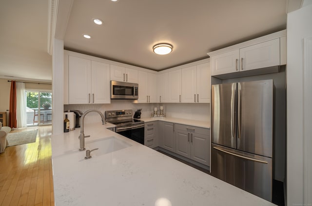 267 Melba St Apt B13, Milford, CT 06460 - kitchen with appliances with stainless steel finishes, white cabinets, recessed lighting, light stone countertops, and hardwood / wood-style floors
