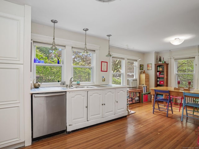 58 Riverdale Ave, Greenwich, CT 06831 - kitchen featuring stainless steel dishwasher, light wood finished floors, plenty of natural light, and tile counters