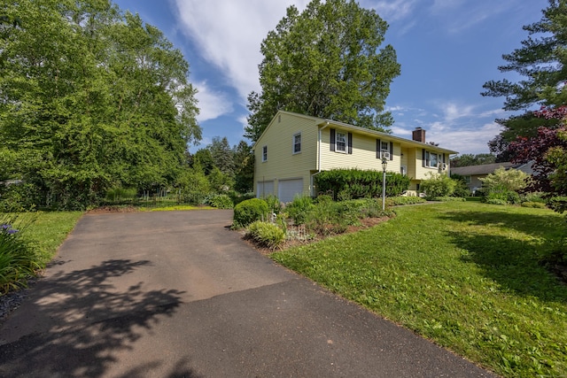 480 Budding Ridge Rd, Cheshire, CT 06410 - split foyer home with a chimney, a garage, asphalt driveway, and a front lawn