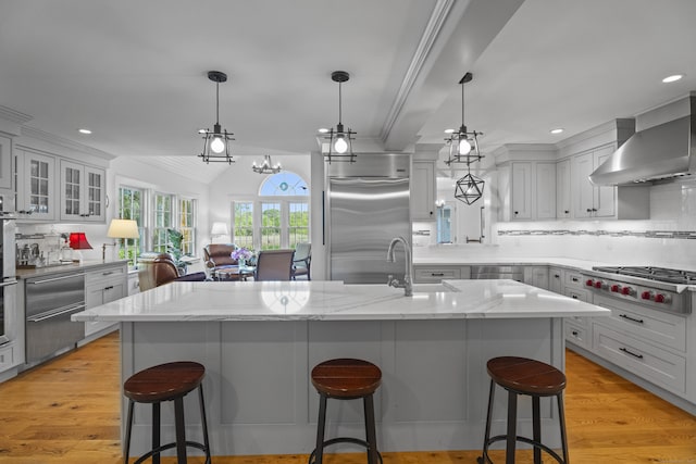 4 Johnny Cake Hill Rd, Old Lyme, CT 06371 - kitchen with appliances with stainless steel finishes, wall chimney range hood, recessed lighting, tasteful backsplash, and a kitchen bar