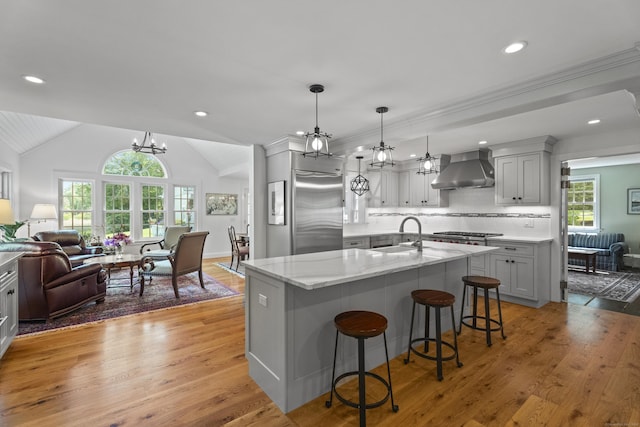 4 Johnny Cake Hill Rd, Old Lyme, CT 06371 - kitchen featuring wall chimney exhaust hood, high end refrigerator, open floor plan, light wood-type flooring, and vaulted ceiling