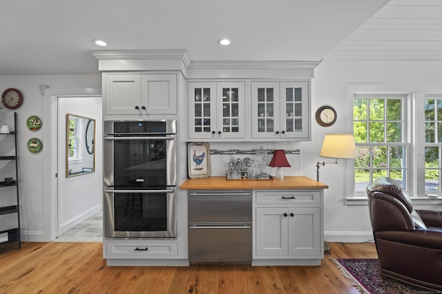 4 Johnny Cake Hill Rd, Old Lyme, CT 06371 - kitchen featuring appliances with stainless steel finishes, wood counters, glass insert cabinets, light wood-type flooring, and white cabinetry