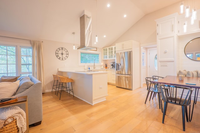 158 Stadley Rough Rd, Danbury, CT 06811 - kitchen featuring stainless steel refrigerator with ice dispenser, extractor fan, light wood finished floors, a peninsula, and a kitchen breakfast bar